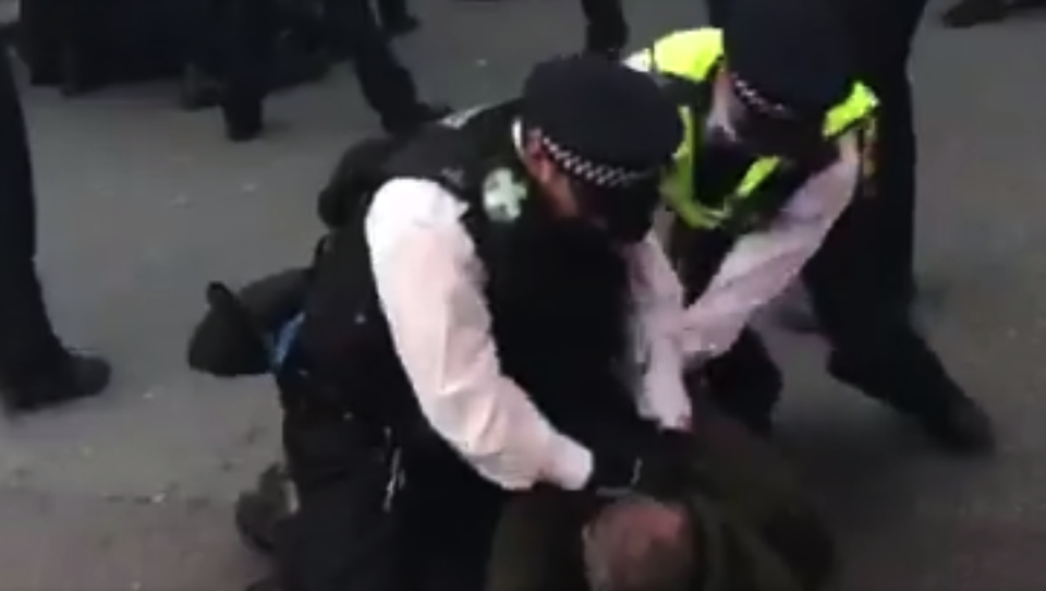 The two men are seen restraining the protester in the footage (Telegraf)