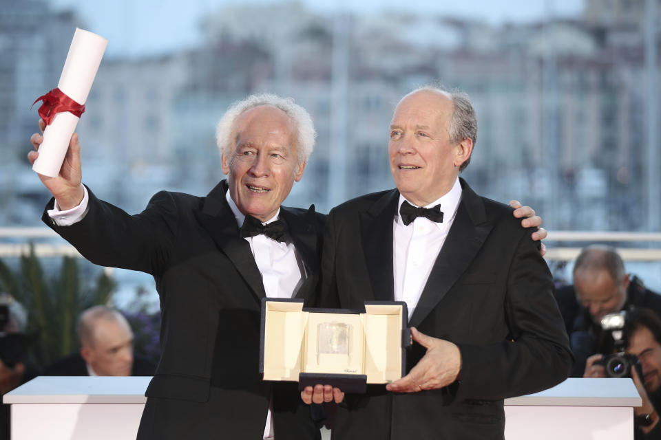 Directors Jean-Pierre Dardenne, left and Luc Dardenne hold their best director award for the film 'Young Ahmed' as they pose for photographers during a photo call following the awards ceremony at the 72nd international film festival, Cannes, southern France, Saturday, May 25, 2019. (AP Photo/Petros Giannakouris)