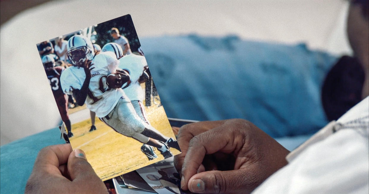 A family member views photo of Kendrick as a youth football player.  (Jason Pollock)