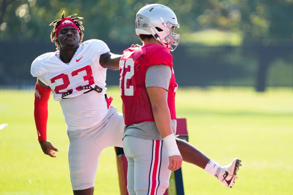 Avery Henry, right, here warming up with Omari Abor has announced that doctors have declared his osteosarcoma is in remission.