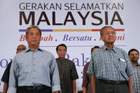 FILE - In this March 27, 2016, photo, Malaysia's former Prime Minister Mahathir Mohamad, right, and former Deputy Prime Minster Muhyiddin Yassin attend the "People's Congress 2016" event in Shah Alam, Malaysia. Bersatu party said in a statement Friday, Feb. 28, 2020 that 36 lawmakers, including nearly a dozen who defected from Anwar Ibrahim's party, have decided to support party President Muhyiddin Yassin instead of Mahathir as prime minister. (AP Photo/Vincent Thian, File)