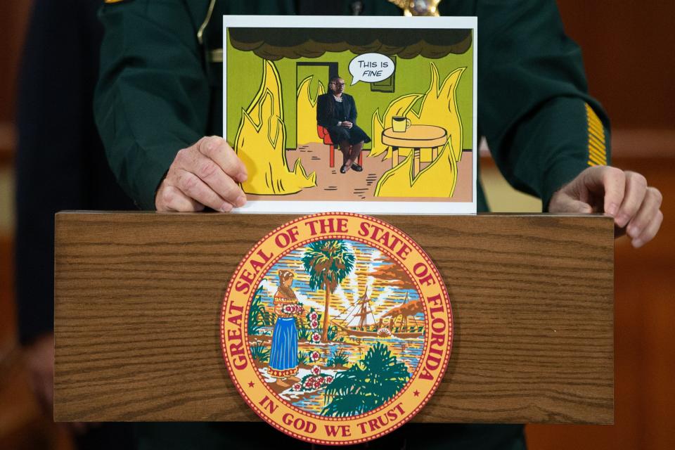 Polk County Sheriff Grady Judd holds up a visual displaying a popular meme that he photoshopped State Attorney Monique Worrell into during a press conference held by Gov. Ron DeSantis so he could announce the suspension Worrell on Wednesday, Aug. 9, 2023.