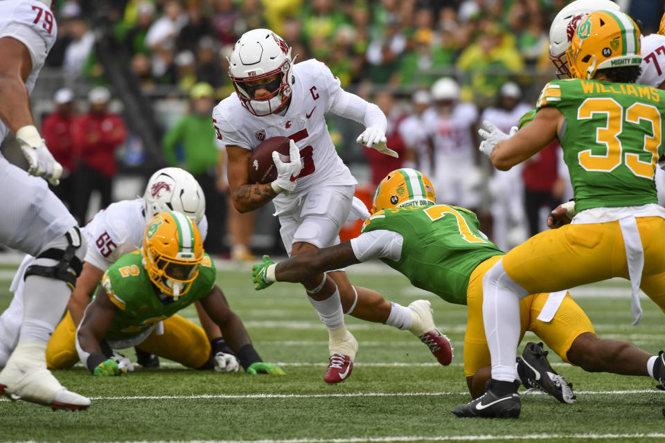 Washington State wide receiver Lincoln Victor (5) looks for running room as Oregon defensive back Steve Stephens IV (7) tries to make a tackle during the first half of an NCAA college football game Saturday, Oct. 21, 2023, in Eugene, Ore. (AP Photo/Andy Nelson)