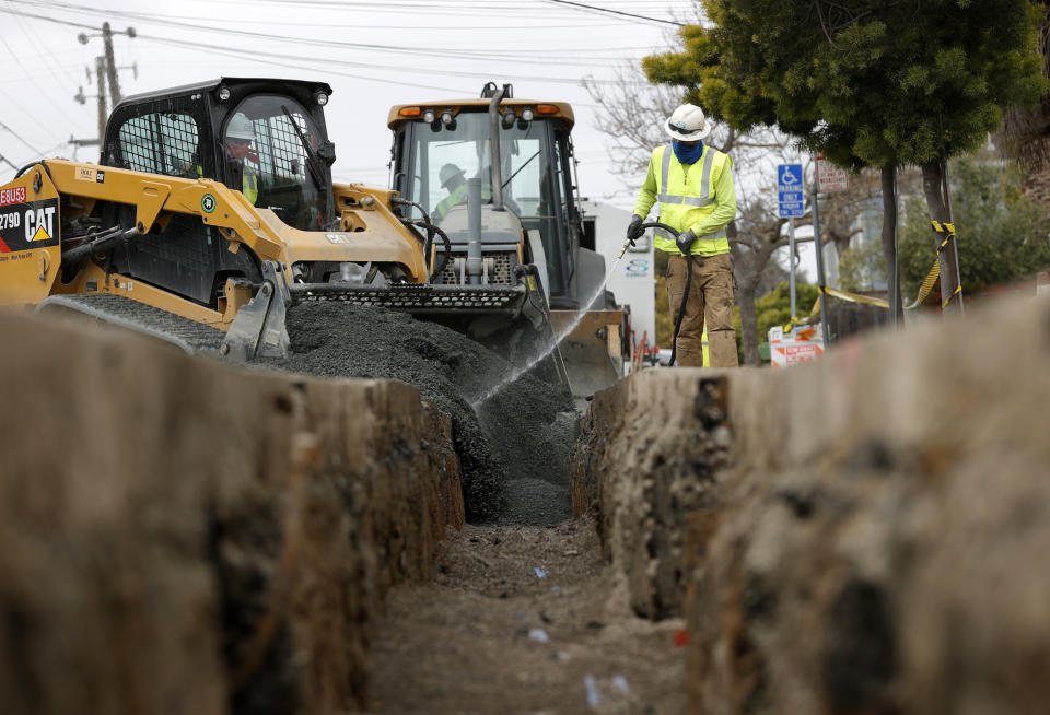 OAKLAND, CALIFORNIA - APRIL 22: Workers with East Bay Municipal Utility District (EBMUD) fill a trench after installing new water pipe on April 22, 2021 in Oakland, California. U.S. President Joe Biden introduced his $2 trillion infrastructure and jobs package that could potentially reshape the American economy. The American Jobs Plan is poised to repair aging roads and bridges, jump-start transit projects and rebuild school buildings and hospitals and would also expand electric vehicles, replace all lead pipes and overhaul the nation’s water systems. (Photo by Justin Sullivan/Getty Images)