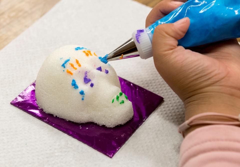 Seven-year-old Rainee Xiao decorates a sugar skull with icing while preparing for Evansville’s Dia de los Muertos at Montessori Academy Wednesday afternoon, Nov. 3, 2021.