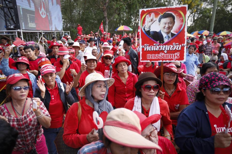 Pro-government protesters show a portrait of former Prime Minister Thaksin Shinawatra during a rally in Aksa, outskirt of Bangkok, Thailand, Saturday, May 10, 2014. Supporters of Thailand's embattled government streamed into western Bangkok for a show of force Saturday that follows Prime Minister Yingluck Shinawatra's ouster and a renewed push by rival demonstrators to install an unelected premier. (AP Photo/Vincent Thian)