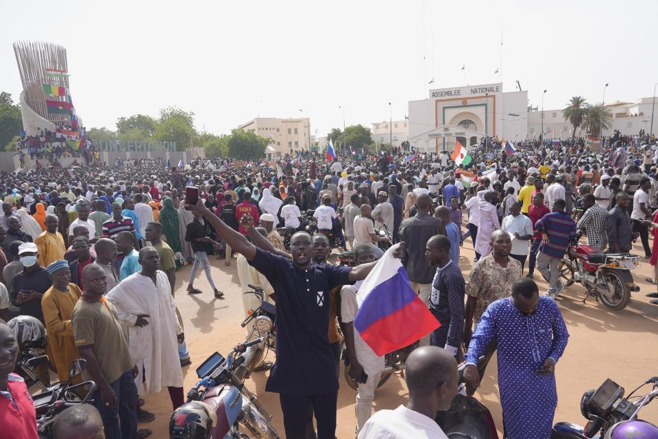 Nigeriens, some holding Russian flags, participate in a march called by supporters of coup leader Gen. Abdourahmane Tchiani in Niamey, Niger, Sunday, July 30, 2023. Not everyone is hostile to last week's coup in Niger. Neighboring Burkina Faso and Mali have taken the unusual step of declaring that foreign military intervention in Niger would be a declaration of war against them, too. Both have had coups in recent years. (AP Photo/Sam Mednick)