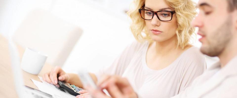 A picture of a worried couple with documents at home