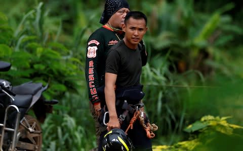 Cavers walks a road leading to the Tham Luang cave complex in the northern province of Chiang Rai - Credit: Reuters