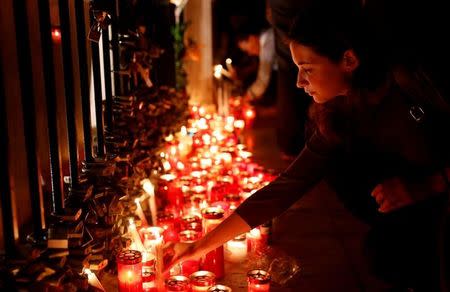 A woman places a candle on the Love monument during a silent candlelight vigil to protest against the assassination of investigative journalist Daphne Caruana Galizia in a car bomb attack, in St Julian's, Malta, October 16, 2017. REUTERS/Darrin Zammit Lupi