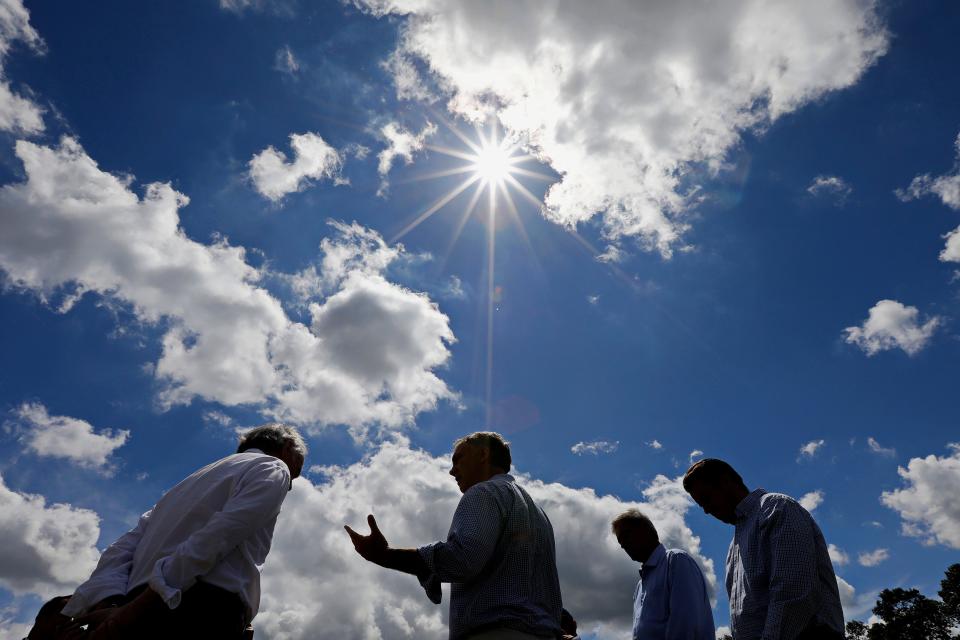 The sun shines down on Mayor Jon Michell as he and Massachusetts Senator Edward J. Markey speak about the Inflation Reduction Act's clean energy investments, during a stop at the solar farm on Hathaway Road.