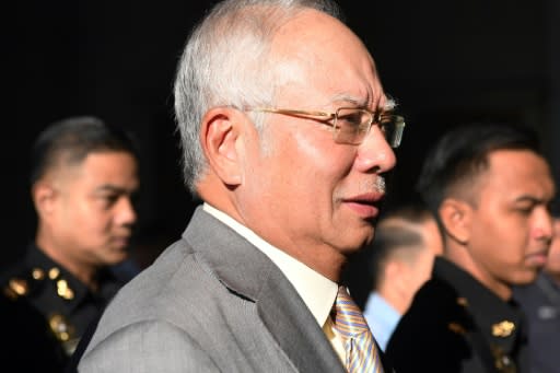 Former Malaysian prime minister Najib Razak is escorted by police after being charged in Kuala Lumpur