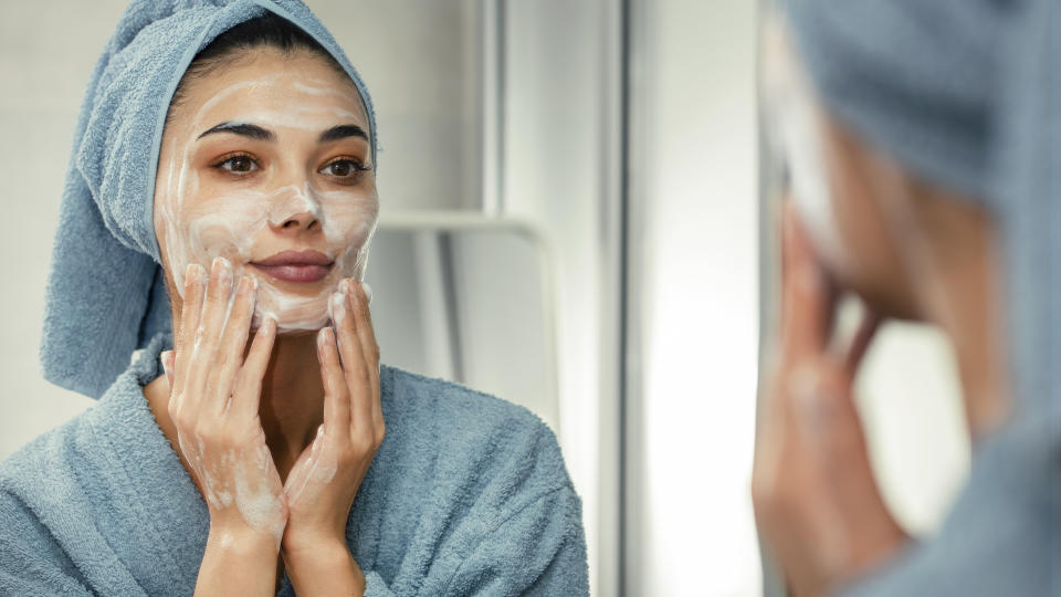 Woman cleansing her face, which is one of the steps of a winter skin care routine
