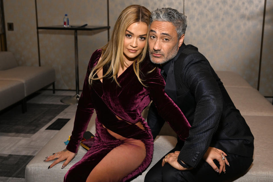 Rita Ora and Taika Waititi sit closely together in evening wear with Champagne Collet & OBC Wines as they celebrate the 27th Annual Critics Choice Awards at Fairmont Century Plaza on March 13, 2022 in Los Angeles, California. 