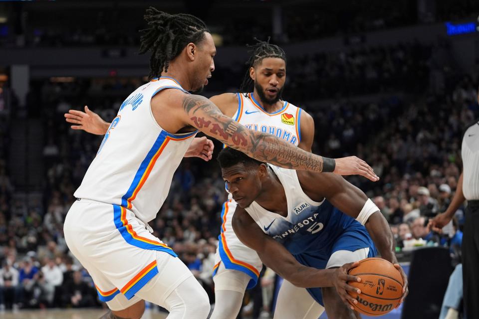 Timberwolves guard Anthony Edwards, right, handles the basketball as Thunder forward Jaylin Williams, left, and guard Isaiah Joe defend during the first half of Saturday's game in Minneapolis.