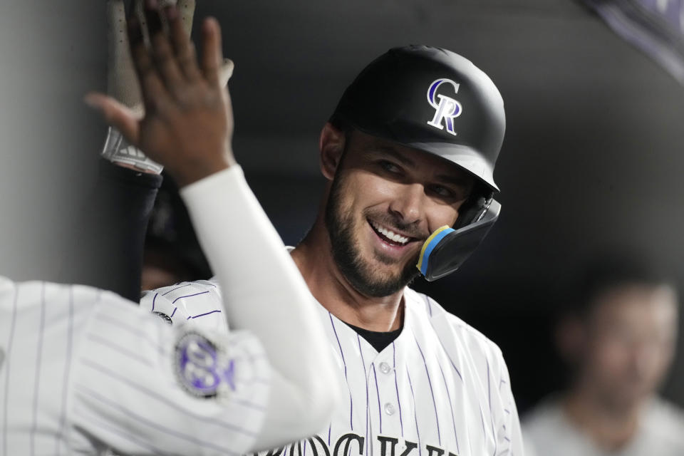 Colorado Rockies' Kris Bryant is congratulated as he returns to the dugout after hitting a solo home run off Chicago Cubs relief pitcher Daniel Palencia during the sixth inning of a baseball game Tuesday, Sept. 12, 2023, in Denver. (AP Photo/David Zalubowski)