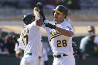 Oakland Athletics' Matt Olson (28) is congratulated by Elvis Andrus after hitting a grand slam home run against the Minnesota Twins during the fourth inning of the first baseball game of a doubleheader in Oakland, Calif., Tuesday, April 20, 2021. (AP Photo/Jeff Chiu)