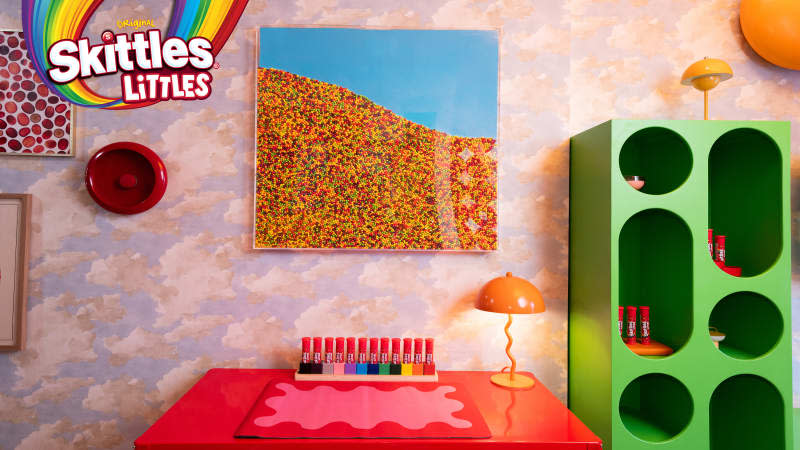 Skittles art above red desk in Skittles Littles apartment, designed by Dani Klaric.