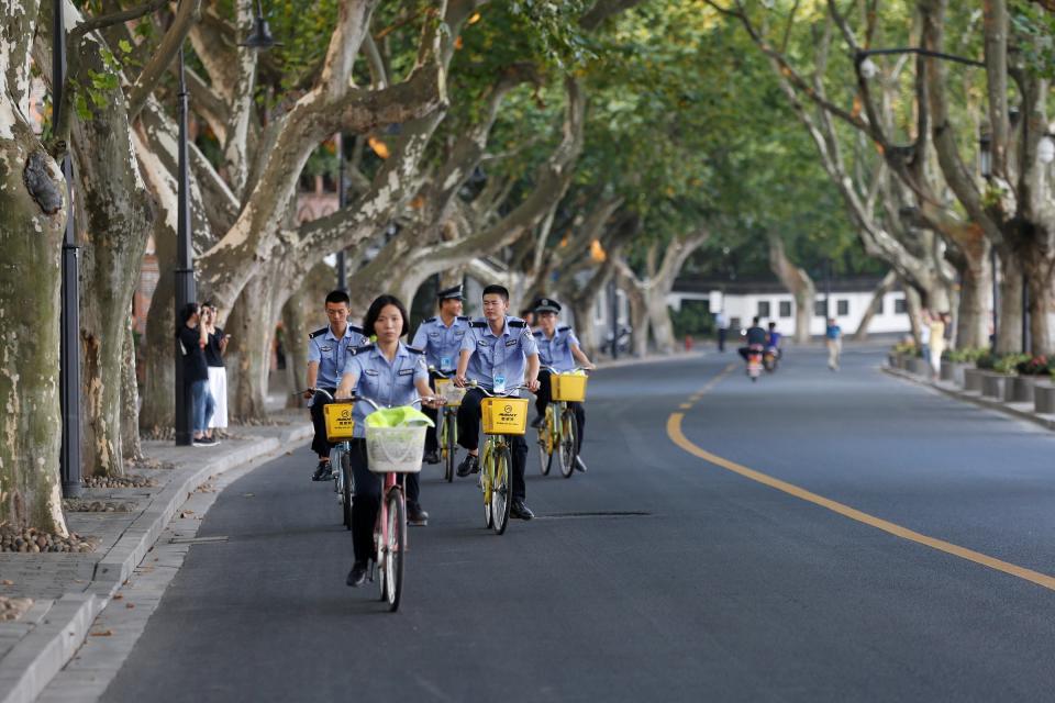 Security personnel ride bicycles on an empty road near the West Lake, as police closed off many roads before G20 Summit in Hangzhou, Zhejiang Province, China August 31, 2016.