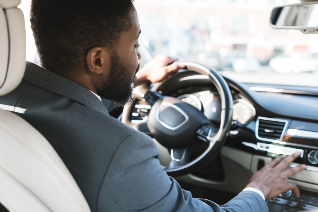 Driving with comfort. Businessman touching dashboard in luxury car