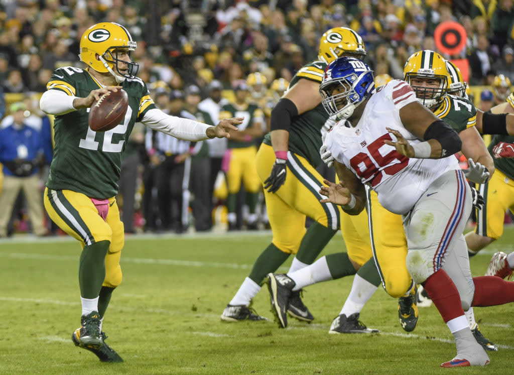 Oct 9, 2016; Green Bay, WI, USA; Green Bay Packers quarterback Aaron Rodgers (12) looks to pass while getting pressure from New York Giants defensive tackle Johnathan Hankins (95) in the third quarter at Lambeau Field. Mandatory Credit: Benny Sieu-USA TODAY Sports