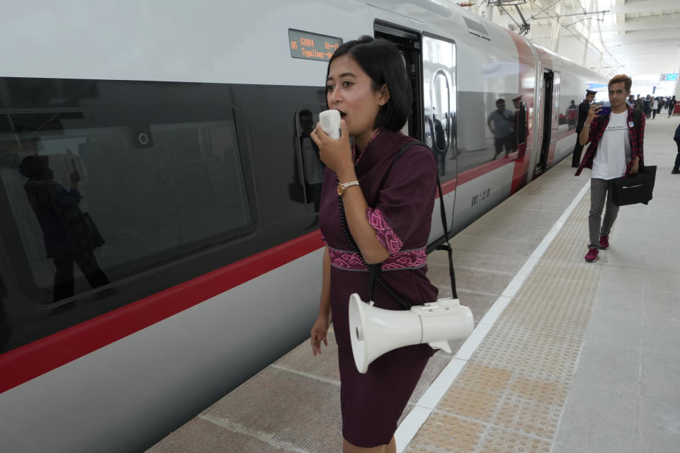 An official uses loudspeaker to remind passengers to board a high-speed train during test ride at Tegalluar station in Bandung, West Java province, Indonesia, on Sept. 18, 2023. Indonesia is launching Southeast Asia’s first high-speed railway, a key project under China’s Belt and Road infrastructure initiative that will cut travel time between the capital and another major city from the current three hours to about 40 minutes. (AP Photo/Achmad Ibrahim)