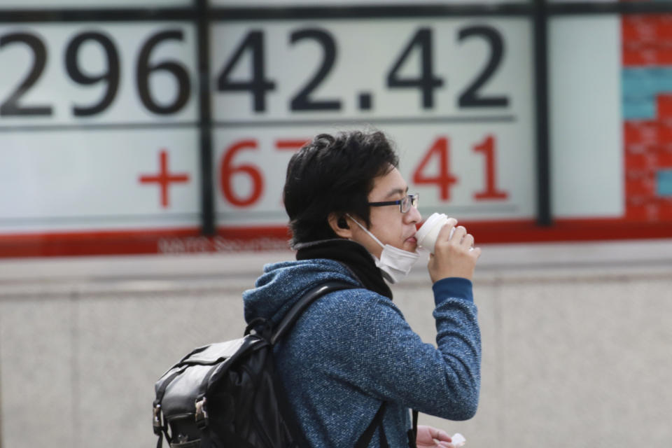 A man stands by an electronic stock board of a securities firm in Tokyo, Monday, March 1, 2021. Asian shares were higher on Monday on hopes for President Joe Biden’s stimulus package and bargain-hunting buying after the shares’ fall last week. (AP Photo/Koji Sasahara)