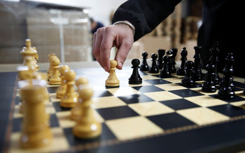 David Ferrer moves a chess pawn on a chessboard at the Rechapados Ferrer factory in La Garriga
