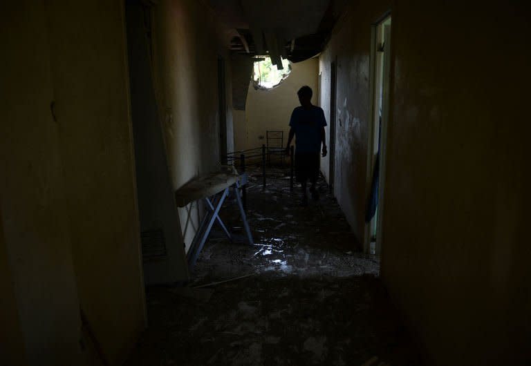 A resident inspects the damage to their house after a mortar shell hit a residential area of Zamboanga, on the southern island of Mindanao, on September 21, 2013. Philippine President Benigno Aquino has flown out of the southern city where troops are fighting Muslim rebels, saying he expects the deadly battles to be over soon