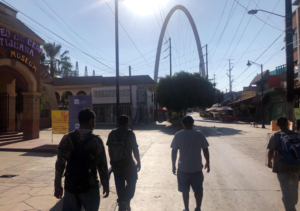 FILE - In this Oct. 8, 2020, file photo Expelled migrants walking in Tijuana, Mexico, Oct. 8, 2020. The Trump administration was more hostile to immigration and immigrants than any decades, making it harder for people to visit, live or work in the United States while also seeking to reduce the number illegally entering the country. (AP Photo/Elliot Spagat, File)