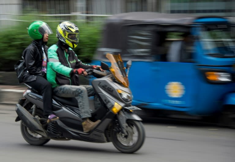 Ride-hailing apps like the Grab motorcyle-taxi seen here are denting the fortunes of traditional three-wheeled bajaj taxis in Indonesia