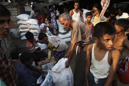 Rohingya people receive their share of food aid from the World Food Program (WFP) at the Thae Chaung camp for internally displaced people in Sittwe, Rakhine state, April 24, 2014. REUTERS/Minzayar