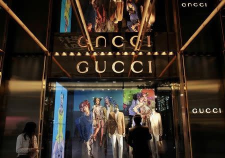 A man looks at a window display outside a Gucci store, part of the Kering group, at Tsim Sha Tsui shopping district in Hong Kong January 17, 2013. REUTERS/Bobby Yip/File Photo