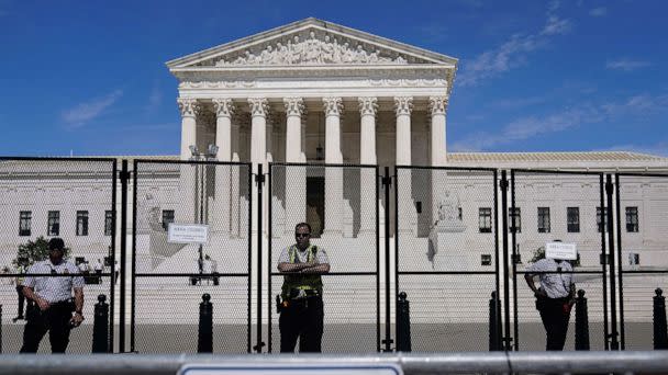 PHOTO: Capitol Police officers stand post behind the temporary anti-scaling fence surrounding the Supreme Court, June 28, 2022. (Mariam Zuhaib/AP)