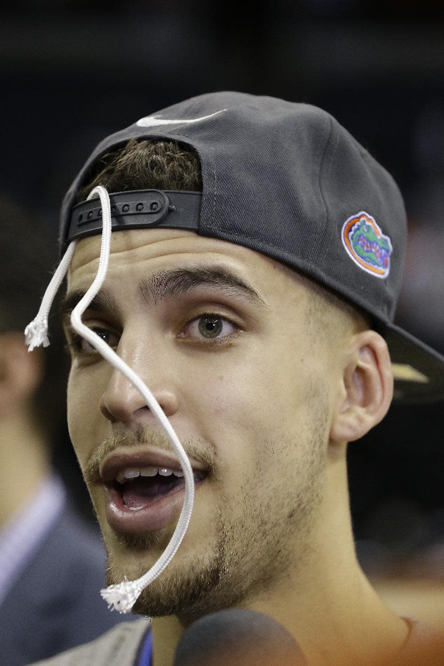 Florida guard Scottie Wilbekin walks off the court with part of the net in his hat after the second half in a regional final game against Dayton at the NCAA college basketball tournament, Saturday, March 29, 2014, in Memphis, Tenn. Florida won 62-52. (AP Photo/Mark Humphrey)