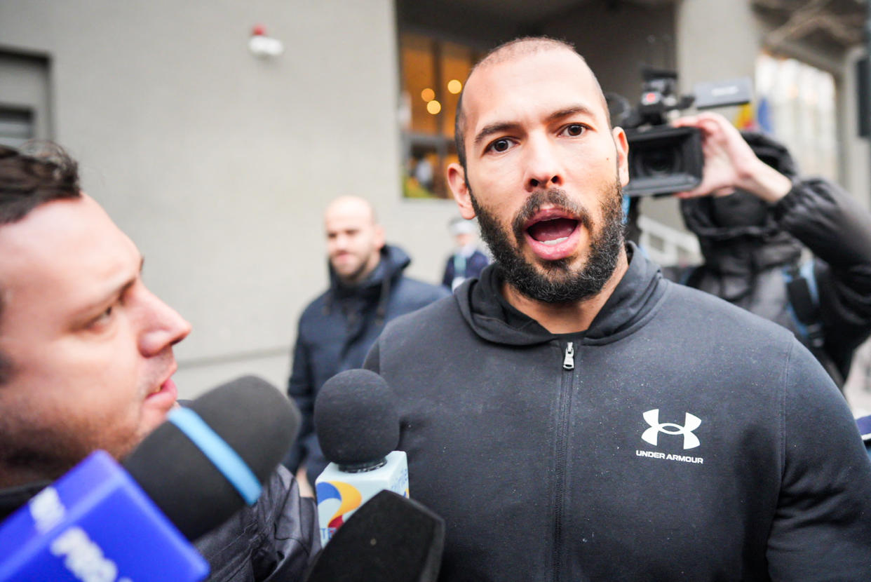 British-US former professional kickboxer and controversial influencer Andrew Tate talks to media as he leaves Romania's anti-organized crime and terrorism directorate (DIICOT), after a digital investigation of devices, where his presence was required, in Bucharest, Romania on January 25, 2023. (Photo by MIHAI BARBU / AFP) (Photo by MIHAI BARBU/AFP via Getty Images)