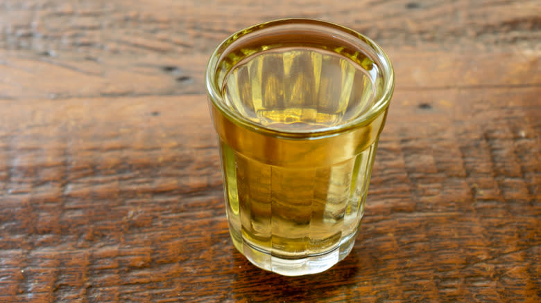 Yellow drink in clear glass on wooden table 