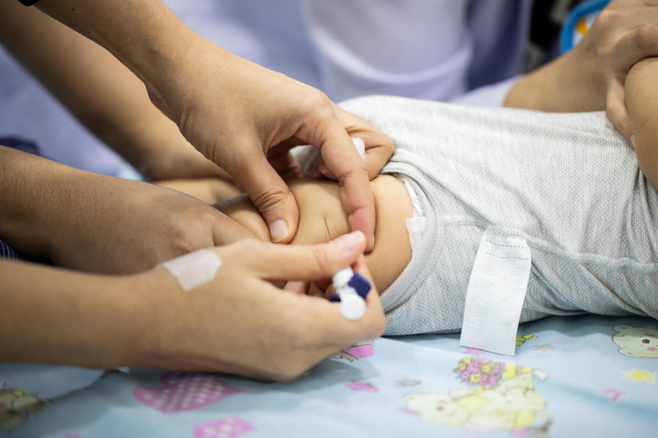 Many doctors and nurses are helping to vaccinate to protect a disease for a baby.