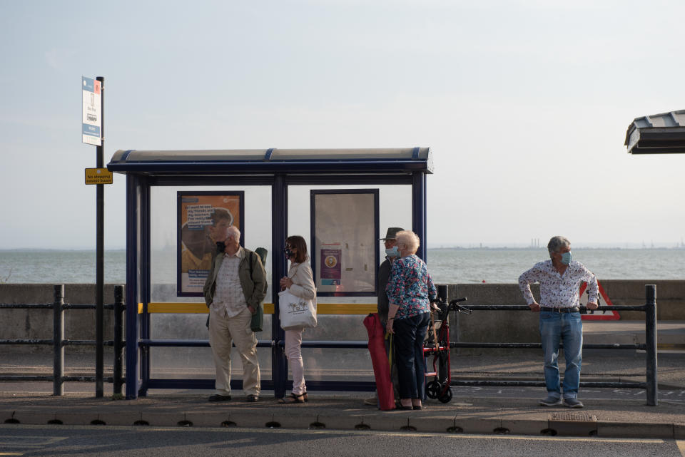 SOUTHEND-ON-SEA, ENGLAND - SEPTEMBER 20: A group of people wearing face masks wait for a bus at the bus stop on September 20, 2020 in Southend on Sea, London. (Photo by John Keeble/Getty Images)