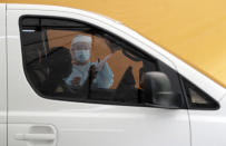 A health worker gets the record of a man as she prepares for his Enhanced Chemiluminescence Immunoassay (ECLIA) antibody test at a drive-thru COVID-19 testing facility at a hospital in metropolitan Manila, Philippines on Wednesday, July 8, 2020. Philippine President Rodrigo Duterte eased one of the world's longest lockdowns in the Philippine capital of more than 13 million people on June 1 after the economy shrank in the first quarter in its first contraction in more than two decades. (AP Photo/Aaron Favila)