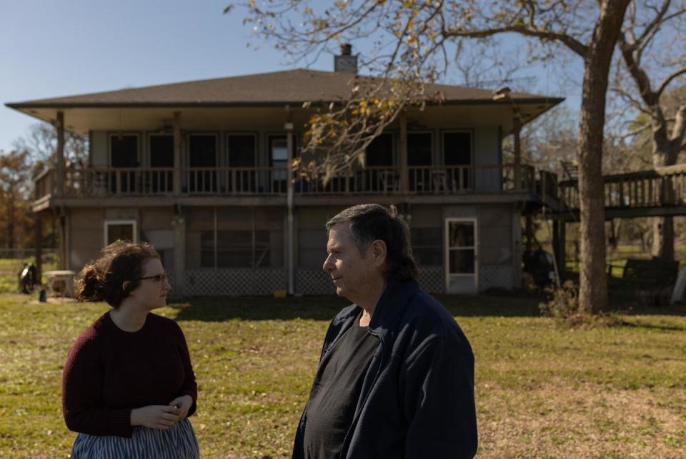 Jerry Barker, right, and his daughter Kat Barker survey Donald Green's old home while attending Green's celebration of life next-door, in Freeport, on Dec. 16, 2023. Green died while running an errand at the bank in September.