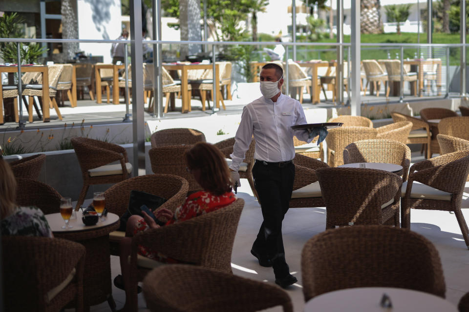 A waiter wearing protective face masks as a measure to help curb the spread of the new coronavirus in Mallorca. (AP)