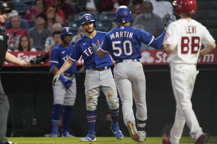 Texas Rangers' Jason Martin (50) celebrates with Nick Solak, center left, after hitting a home run during the second inning of a baseball game against the Los Angeles Angels Friday, Sep. 3, 2021, in Anaheim, Calif. Solak also scored. (AP Photo/Ashley Landis)