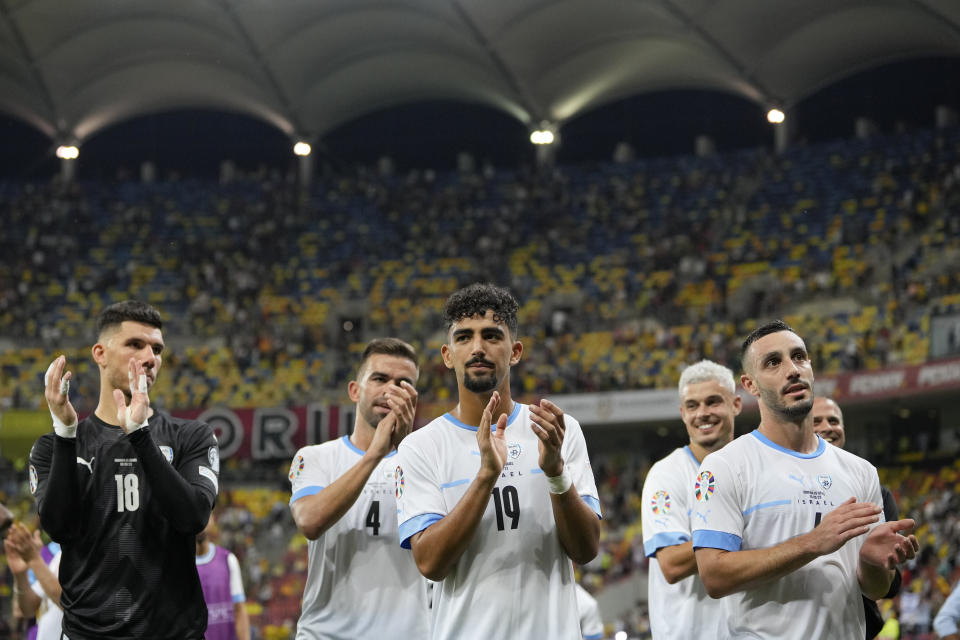 FILE - Israel's players applaud their fans at the end of the Euro 2024 qualifying soccer match between Romania and Israel at the National Arena stadium in Bucharest, Romania, Saturday, Sept. 9, 2023. Even before last month’s Hamas attacks in Israel, the leader of Hungary had long promoted his country as the safest in Europe for Jews. Now the Israeli men’s soccer team is taking his word and heading to a tiny Hungarian village as it prepares to play its remaining home games in the Euro 2024 qualifying tournament. Israel will host “home” games against Switzerland next Wednesday, Nov. 15, 2023. and Romania three days later. (AP Photo/Andreea Alexandru, File)