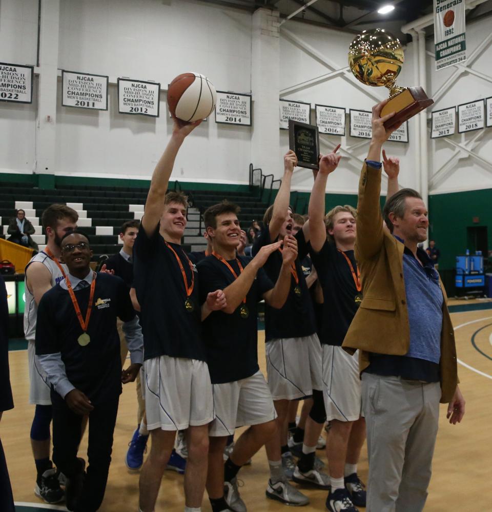 Chapel Field's boys basketball team head coach, Brad McDuffie raises their trophy after winning the Section 9 Class D boys basketball final versus Roscoe at SUNY Sullivan on March 1, 2023. 