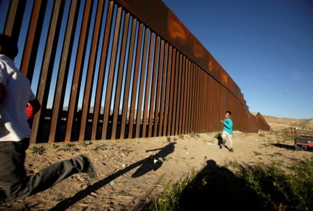 Children run along the border fence between Mexico and the United States during an inter-religious service against U.S. President Donald Trump's border wall, in Ciudad Juarez