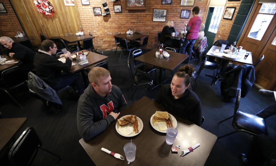 Eddie Kramer eats breakfast with his wife, Abby, at the Engine House Cafe in Lincoln, Neb., on Wednesday, Jan. 4, 2017. The Kramers, who both work for insurance companies and voted for Donald Trump, hope their health insurance bills shrink. They are bothered by how much they pay for their family of four, including two young children; their monthly premiums rose by about $50 last year, and they still had to pay $80 for required medications after their 7-year-old’s tonsils were removed. (AP Photo/Charlie Neibergall)