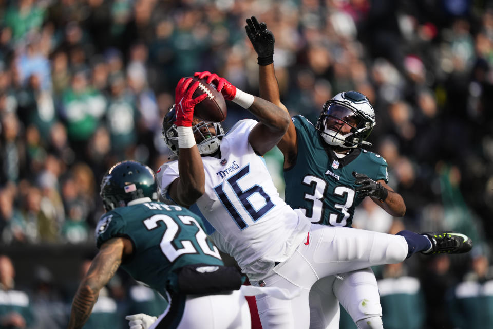 Tennessee Titans' Treylon Burks catches the ball for a touchdown during the first half of an NFL football game in front of Philadelphia Eagles' Marcus Epps, left, and Eagles' Josiah Scott, right, Sunday, Dec. 4, 2022, in Philadelphia. (AP Photo/Matt Slocum)