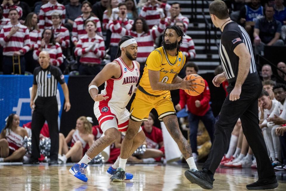 Long Beach State guard Marcus Tsohonis (0) looks around Arizona guard Kylan Boswell (4)