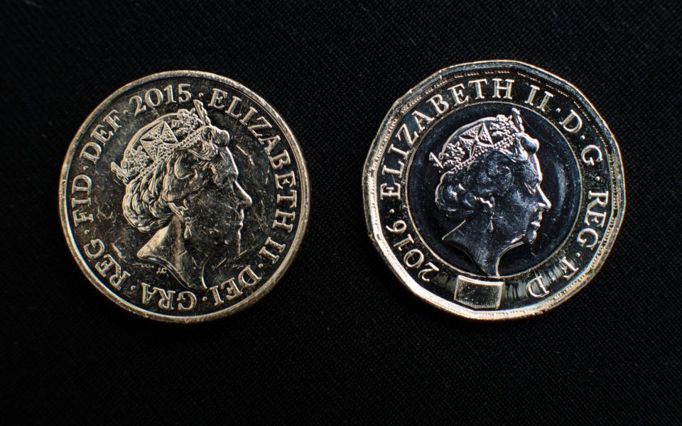 The newly issued £1 (GBP) (one pound) coin (R) is arranged on display beside the old version  - Credit: Jack Taylor/Getty 